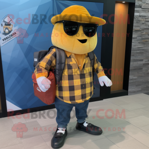 Gold Shakshuka mascot costume character dressed with a Flannel Shirt and Messenger bags