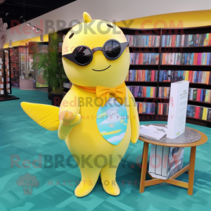 Yellow Narwhal mascot costume character dressed with a Romper and Reading glasses