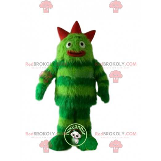 Monstro de mascote verde, cabeludo e divertido. Terno verde -