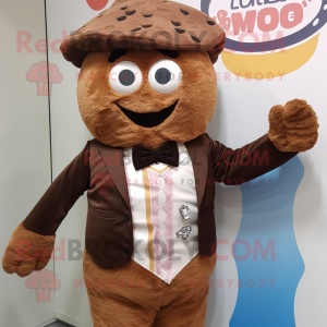 Personaje de disfraz de mascota de cupcake marrón vestido con un chaleco y tirantes
