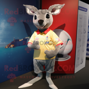 Personaje de disfraz de mascota de canguro plateado vestido con una camiseta de rugby y pinzas para el cabello