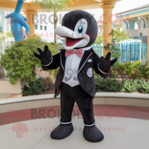 Black Killer Whale mascot costume character dressed with a Bermuda Shorts and Bow ties