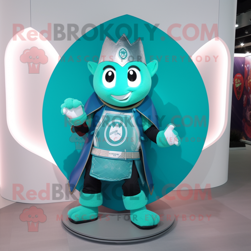 Turquoise Celtic Shield mascot costume character dressed with a Moto Jacket and Shoe clips Turquoise Celtic Shield mascot costume character dressed with a Moto Jacket and Shoe clips