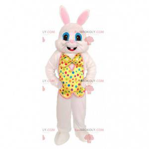 White rabbit mascot with a yellow vest with colored dots -