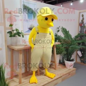 Lemon Yellow Dove mascot costume character dressed with a Dungarees and Hat pins