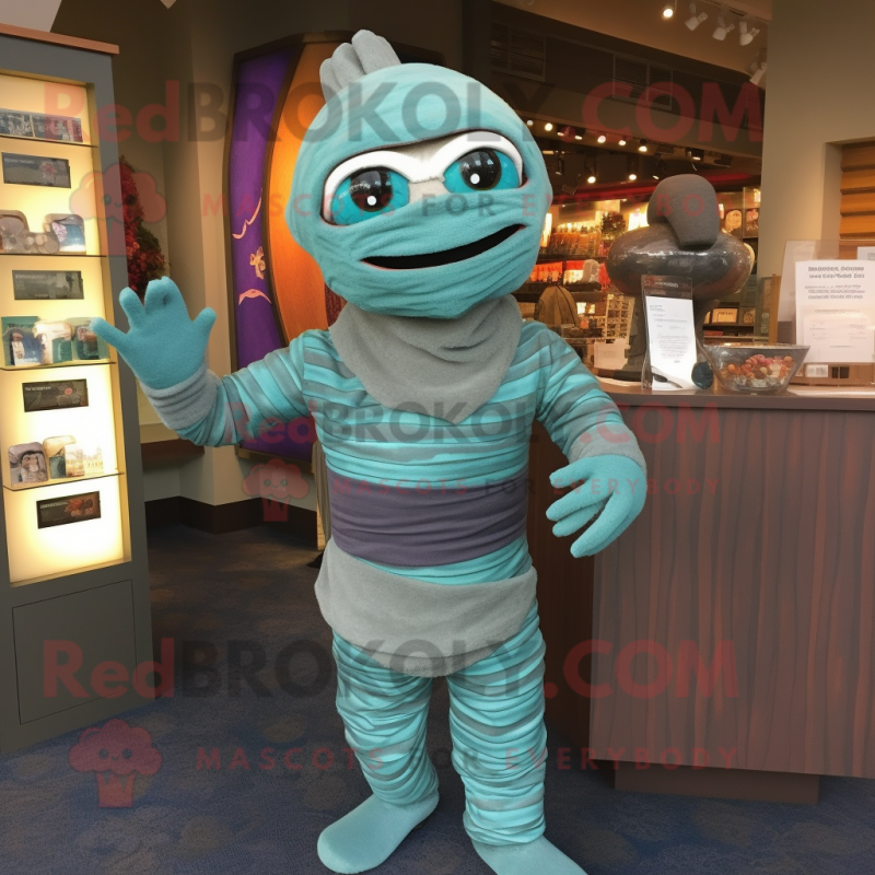 Teal Mummy mascot costume character dressed with a Sweater and Earrings Teal Mummy mascot costume character dressed with a Sweater and Earrings