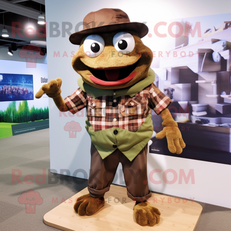 Brown Frog mascot costume character dressed with a Flannel Shirt and Hat pins