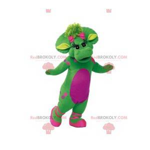 Green female dinosaur mascot with pink polka dots and her