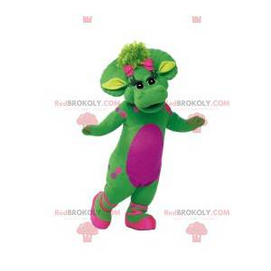 Mascote de dinossauro fêmea verde com bolinhas rosa e seu