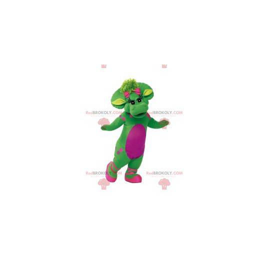 Grønn kvinnelig dinosaur-maskot med rosa prikker og den lille