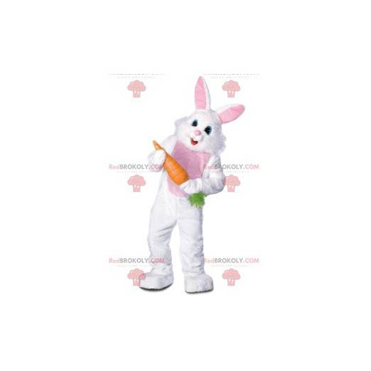 Mascote do coelho branco alegre carregando uma grande cenoura -