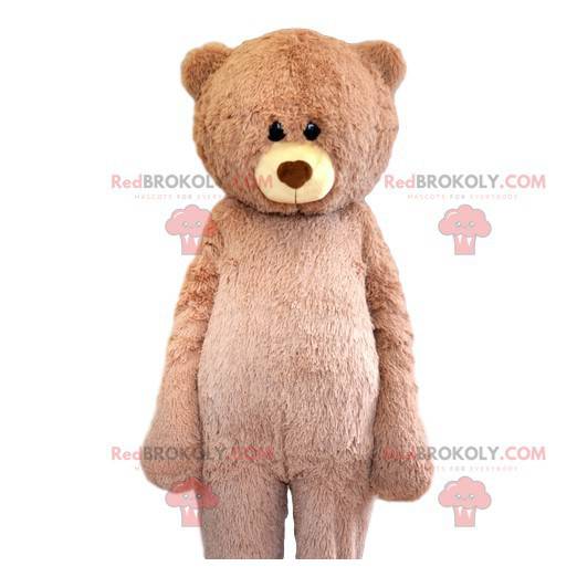 Mascote urso bege muito fofo com seu olhar terno -