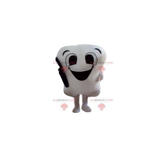 Roztomilý bílý zub maskot s jeho černý kartáček na zuby -