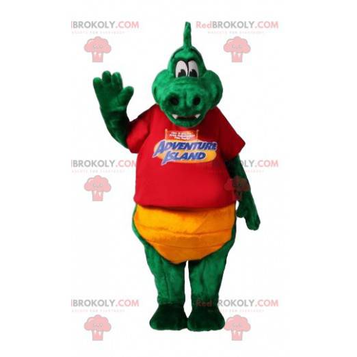 Mascota dinosaurio verde con su camiseta roja y pantalones