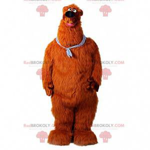 Mascote gigante do urso marrom com uma bandana no pescoço -