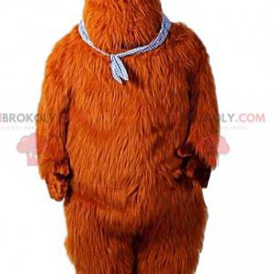 Mascote gigante do urso marrom com uma bandana no pescoço -