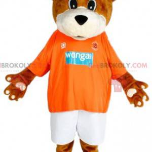Brun bjørnemaskot med sin oransje trøye til støtte -