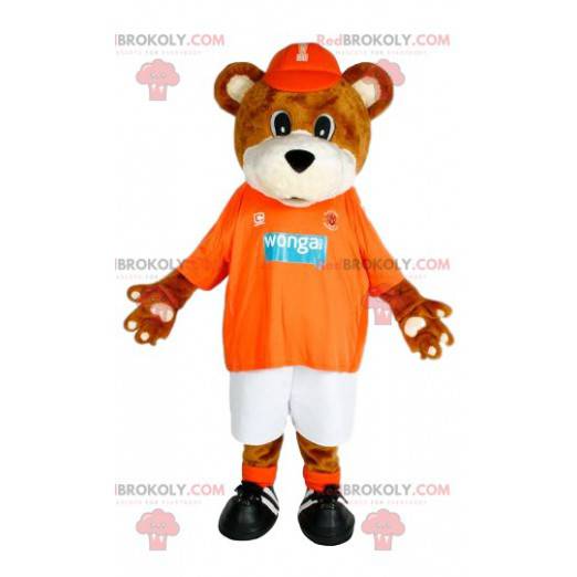 Brun bjørnemaskot med sin oransje trøye til støtte -