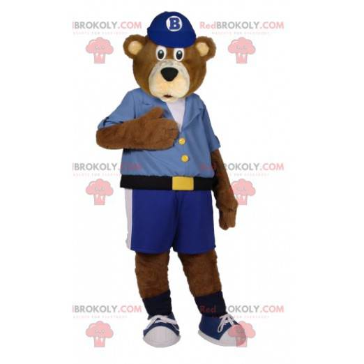 Mascota del oso pardo en pantalones cortos azules y camisa -