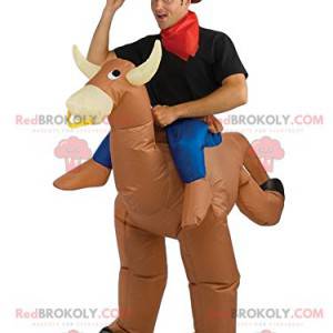 Beige rodeo cow mascot with its rider - Redbrokoly.com