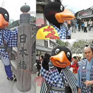 Mascotte d'oiseau noir et orange avec un bouclier jaune -