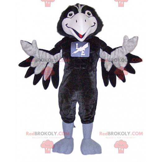 Mascotte di corvo bianco e nero molto sorridente -