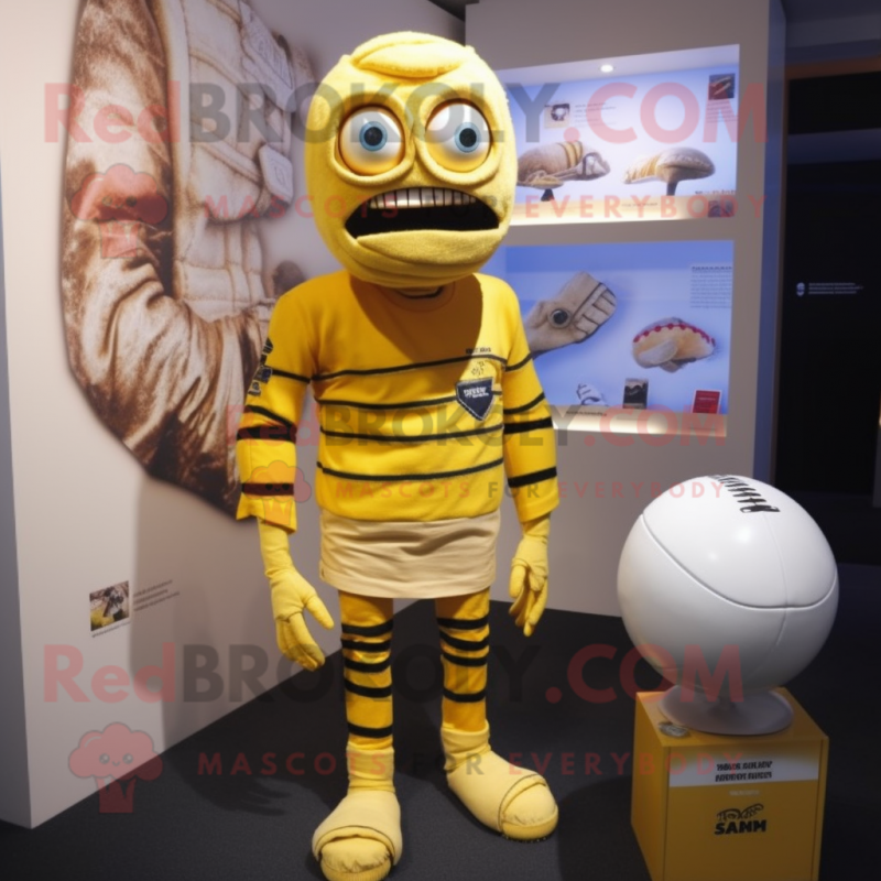 Yellow Mummy mascot costume character dressed with a Rugby Shirt and Earrings Yellow Mummy mascot costume character dressed with a Rugby Shirt and Earrings