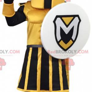 Mascotte de guerrier jaune et noir avec un bouclier. -