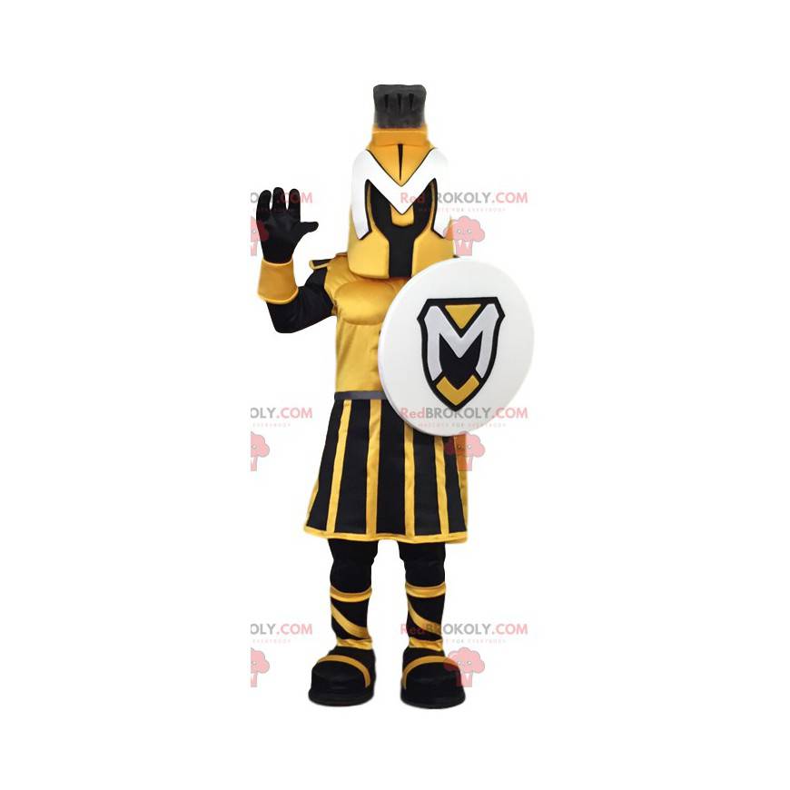 Mascote guerreiro amarelo e preto com um escudo. -