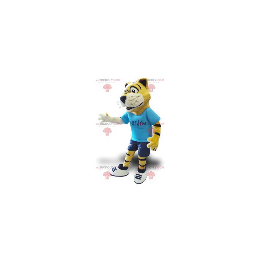 Gelbes Schwarzweiss-Tigermaskottchen mit einem blauen Outfit -