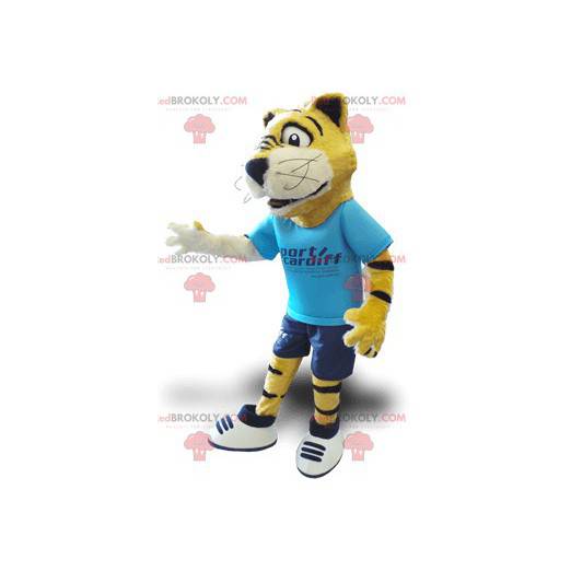 Mascote tigre amarelo preto e branco com uma roupa azul -