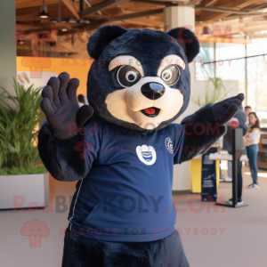 Navy Spectacled Bear mascot costume character dressed with a Graphic Tee and Mittens