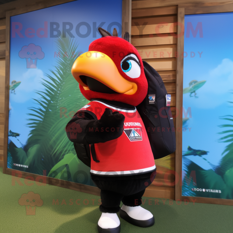 Red Toucan mascot costume character dressed with a Rugby Shirt and Backpacks