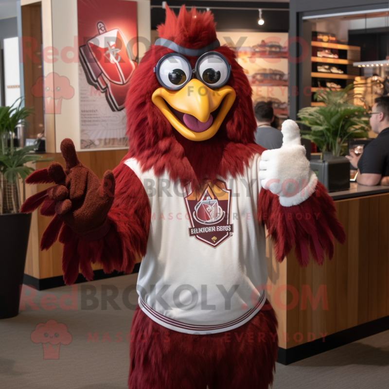 Maroon Rooster mascot costume character dressed with a Graphic Tee and Rings