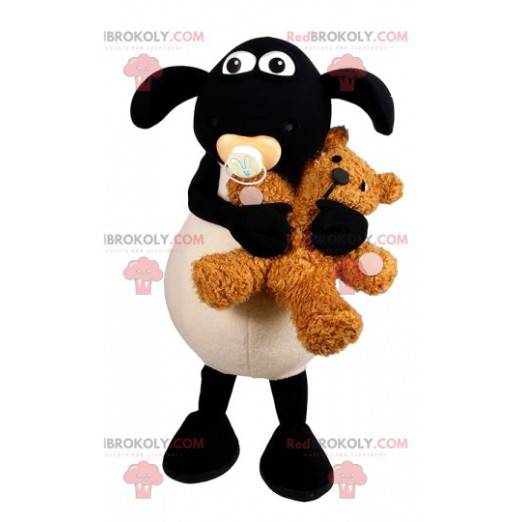 Mascotte di pecora bianca e nera con un orsacchiotto -