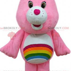 Mascotte orso rosa cura con un arcobaleno sullo stomaco. -