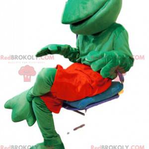 Mascota amigable rana verde con pantalones cortos rojos -