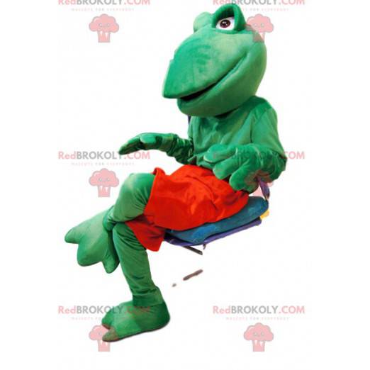Mascote sapo verde amigável com shorts vermelhos -