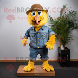 Gold Kiwi mascot costume character dressed with a Denim Shirt and Shoe clips