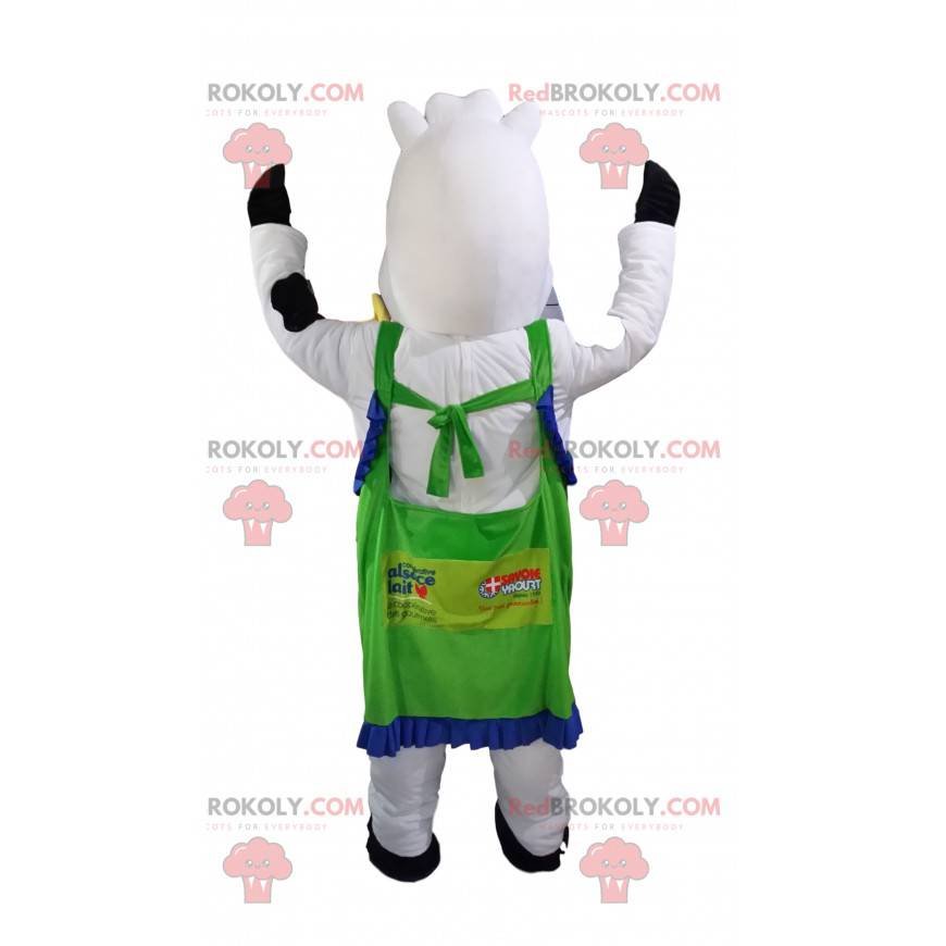 Mascotte de vache blanche et noire avec un tablier vert. -