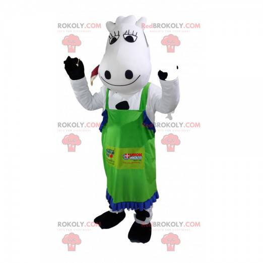 Vaca mascote branca e preta com um avental verde. -