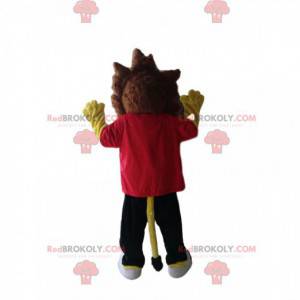 Gul løvemaskott med rød t-skjorte og svarte bukser -