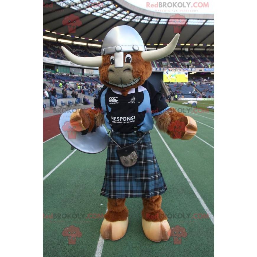 Mascotte de vache marron de taureau avec un kilt et un casque -