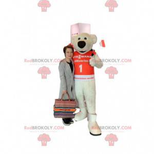 Mascot oso beige con un gran hocico negro y una camiseta roja -