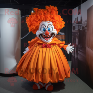Personaje de disfraz de mascota Orange Evil Clown vestido con una falda y cintas para la cabeza