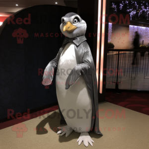 Personaje de traje de mascota de pingüino gris vestido con un vestido de noche y cinturones