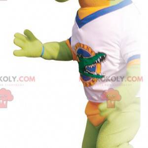 Mascotte coccodrillo verde e arancione con una t-shirt -