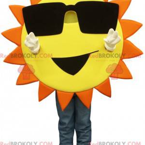 Mascotte de soleil jaune et orange avec des lunettes de soleil