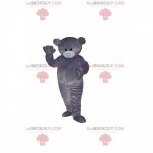 Mascota del oso gris con un hocico azul en forma de corazón -