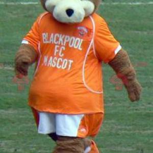 Brown and white teddy bear mascot with an orange outfit -